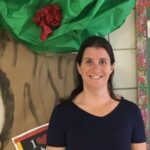 dark haired woman standing in front of a tissue paper tree